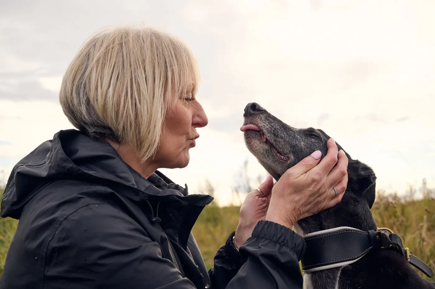 lady with greyhound on nature reserve